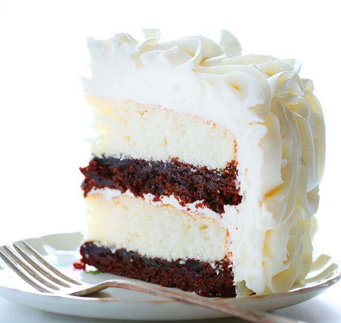 令人惊叹的玫瑰花结覆盖着这个美味的蛋糕。。。白色蛋糕层与丰富的松软巧克力美味相得益彰！