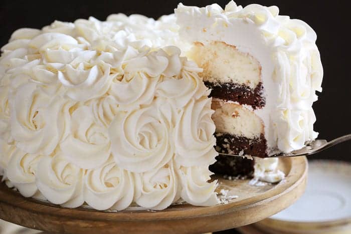 美味的蛋糕上点缀着迷人的玫瑰花。白色的蛋糕层辅以丰富的软糖布朗尼的美味!