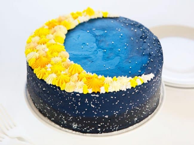 这是一个深蓝色星系蛋糕的侧面图，上面有一个月亮!