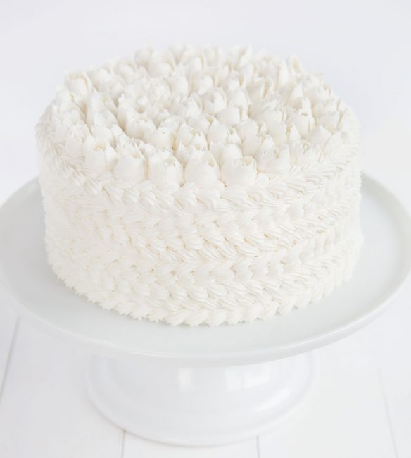 WASC蛋糕用白奶油装饰，白色蛋糕架上有装饰提示。bob投注体育网站