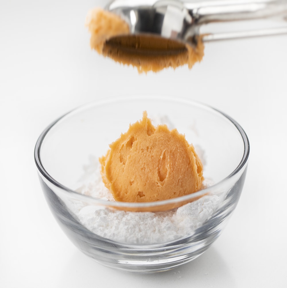 橙色乳膏曲奇饼面团被删去成碗搽粉的糖