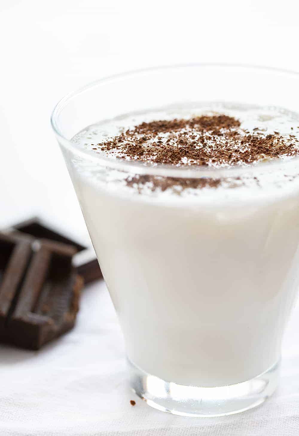 白色巧克力马蒂尼鸡尾酒用在上面和巧克力的被刮的巧克力在背景中
