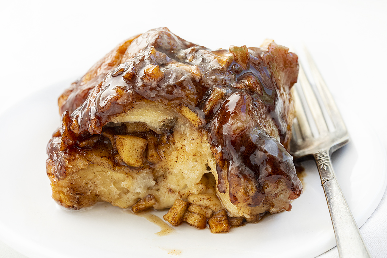 一块苹果油条猴面包在盘子上与叉子