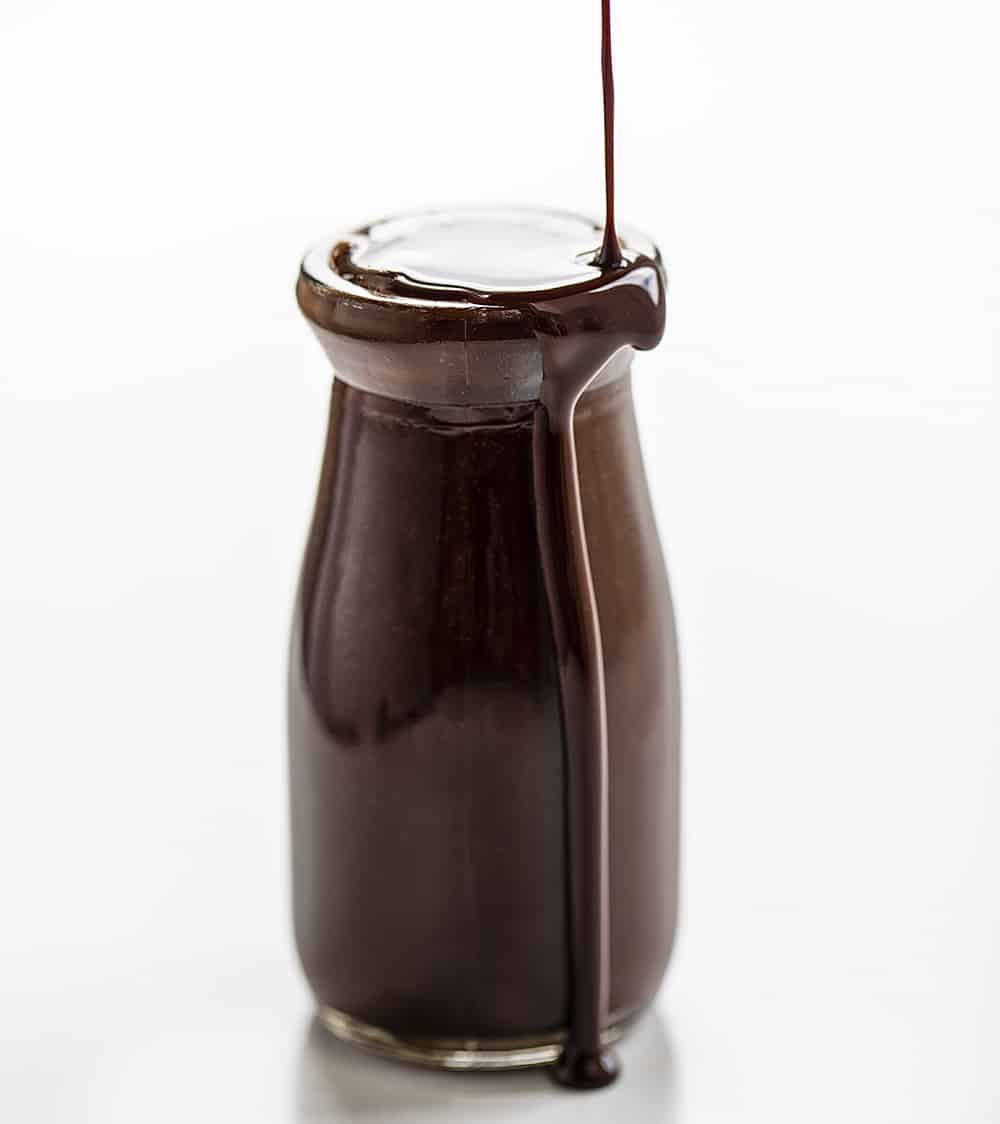 将巧克力糖浆倒入罐子里，它溢出在边缘