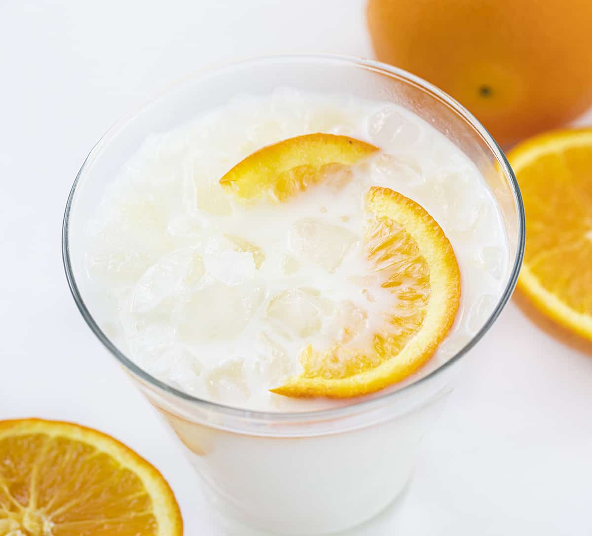 与橙色切片和被击碎的冰的被冰的橙色乳脂状饮料