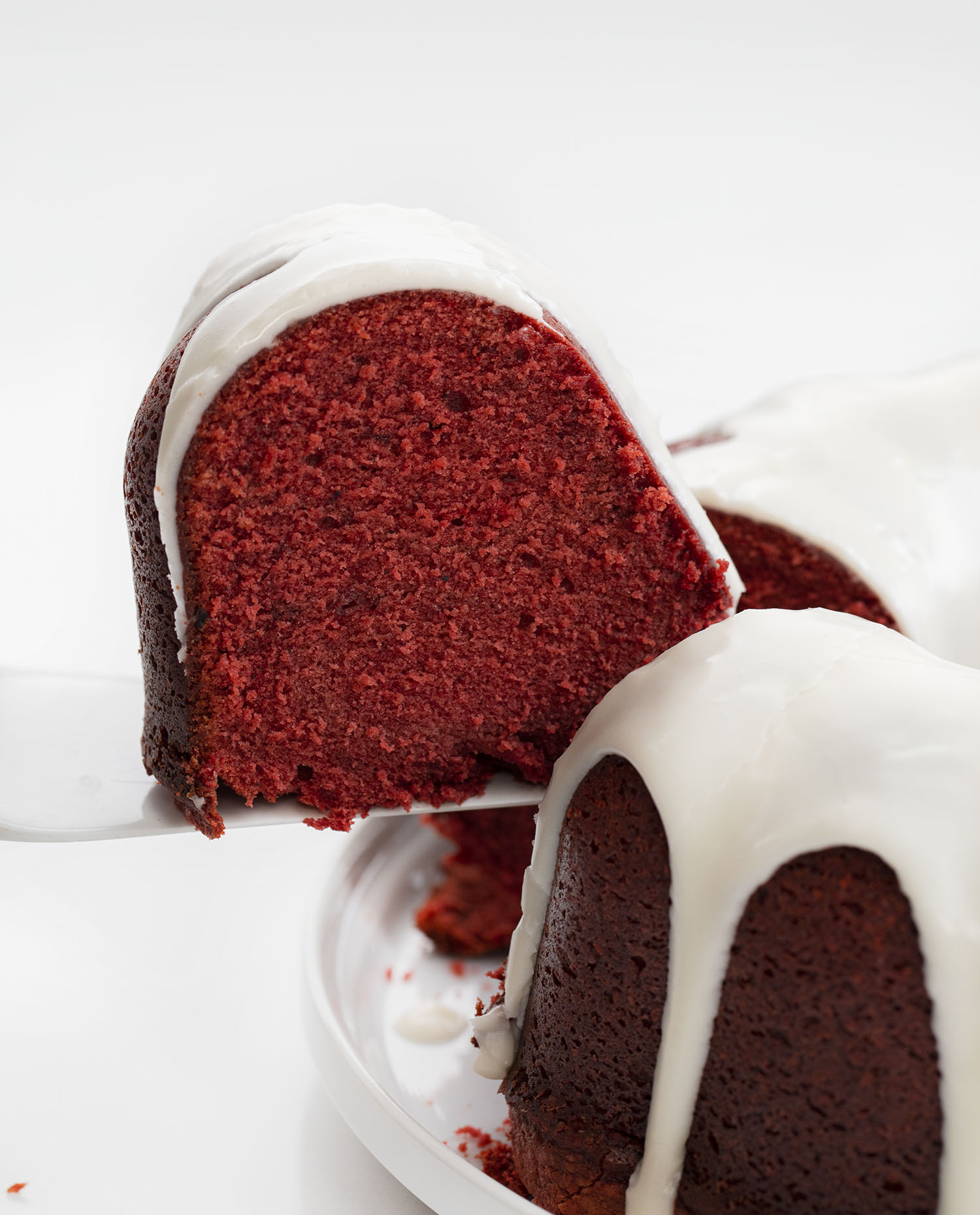 拿起一块红色天鹅绒磅蛋糕用奶油芝士釉