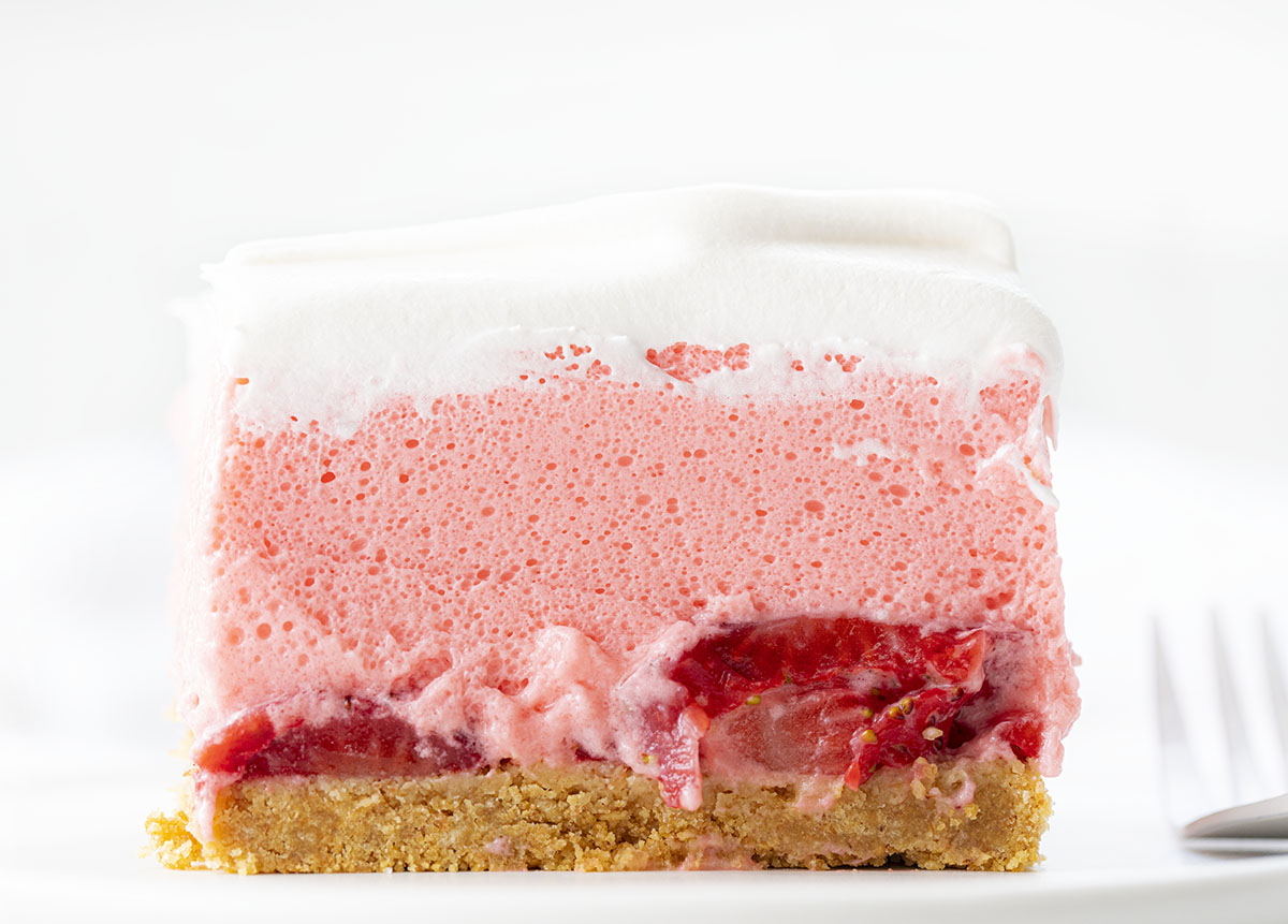 一块草莓冰盒芝士蛋糕，上面有叉子