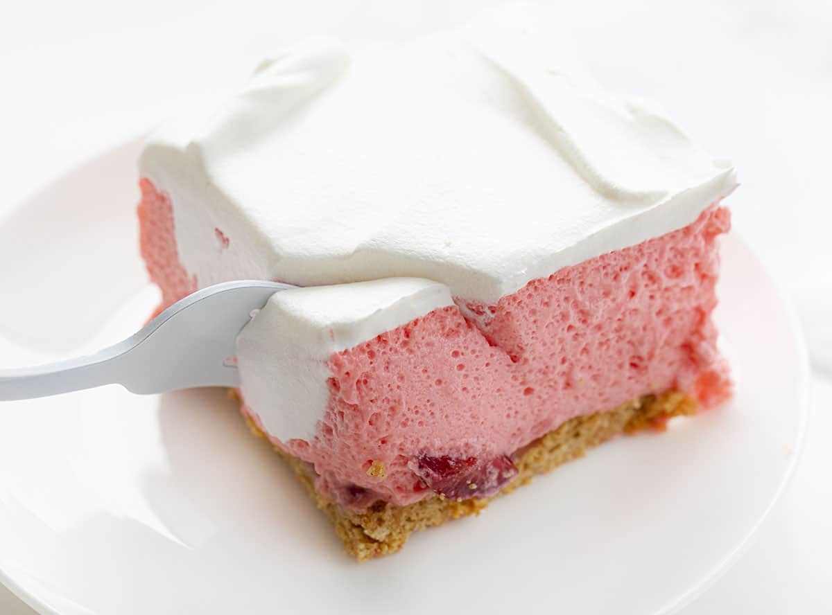 叉子咬一口草莓冰盒芝士蛋糕
