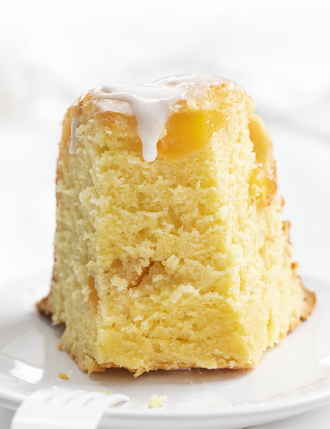 切片桃子磅蛋糕用在白色板材的香草釉