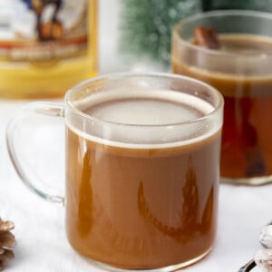 一杯热黄油朗姆酒在柜台朗姆酒和圣诞节装饰品上。